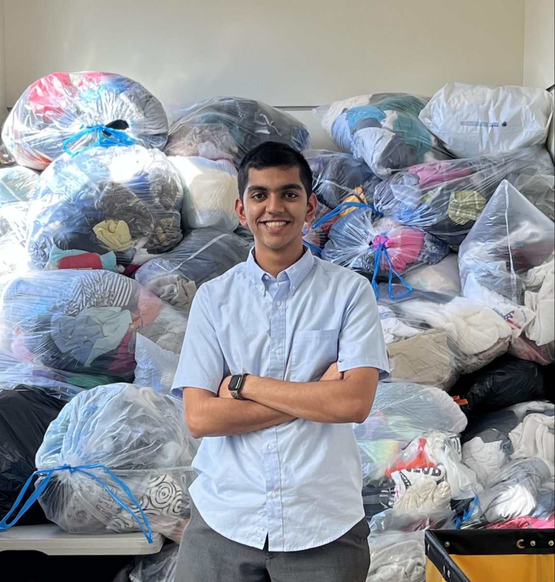 Senior Arnav Lahoti stands in front of all of the clothes that were donated.