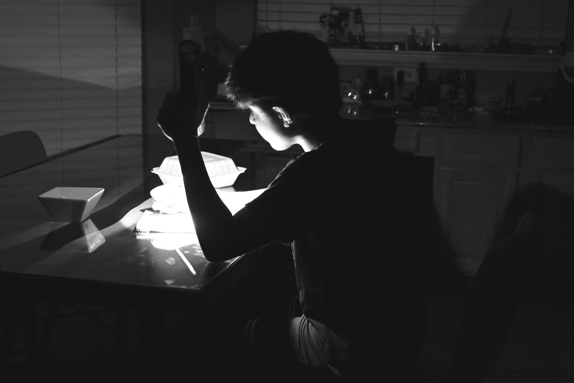 DARKNESS Junior Akul Mittal studies in the dark, waiting for his power to be turned back on. His only source of light: a flashlight.