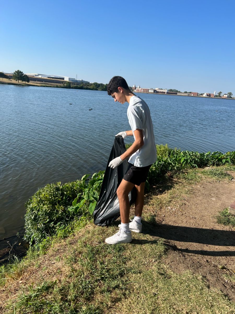 Junior Maddox Canham looks for trash scattered around Bachman Lake.