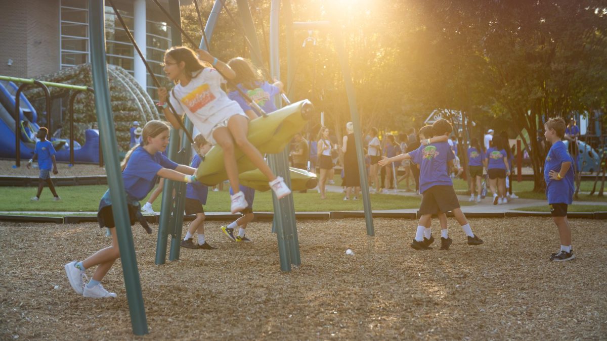 Golden light washes over students from Hockaday and St. Marks as they play on the many playground areas at Fun Day.