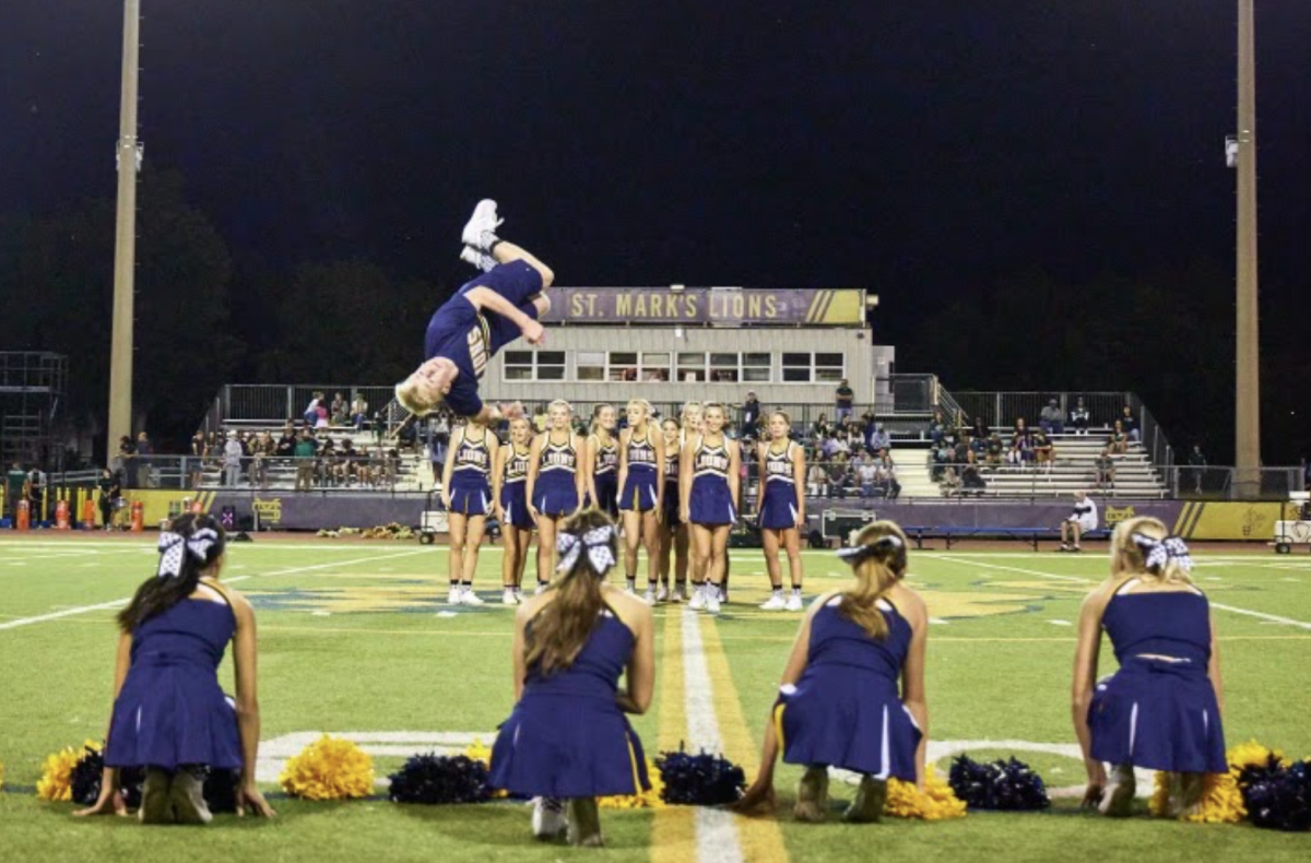 Junior Gavin Bowles twirls through the air at halftime of a football game.
