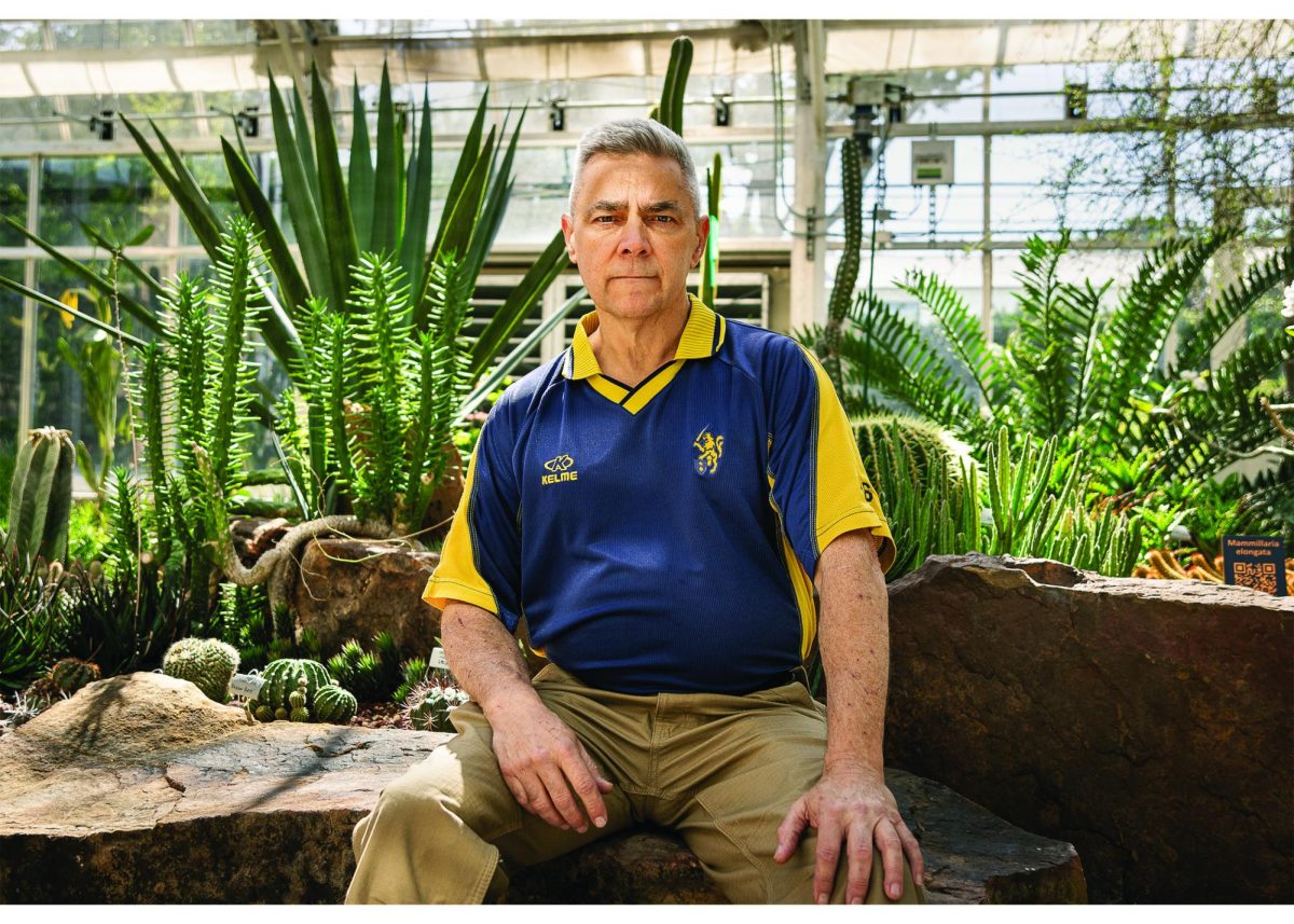 Northcut sits amongst the various plants in the desert room of the Greenhouse. Certified as a Texas Master Naturalist, he has the arduous task of maintaining the Greenhouse on a daily basis.
