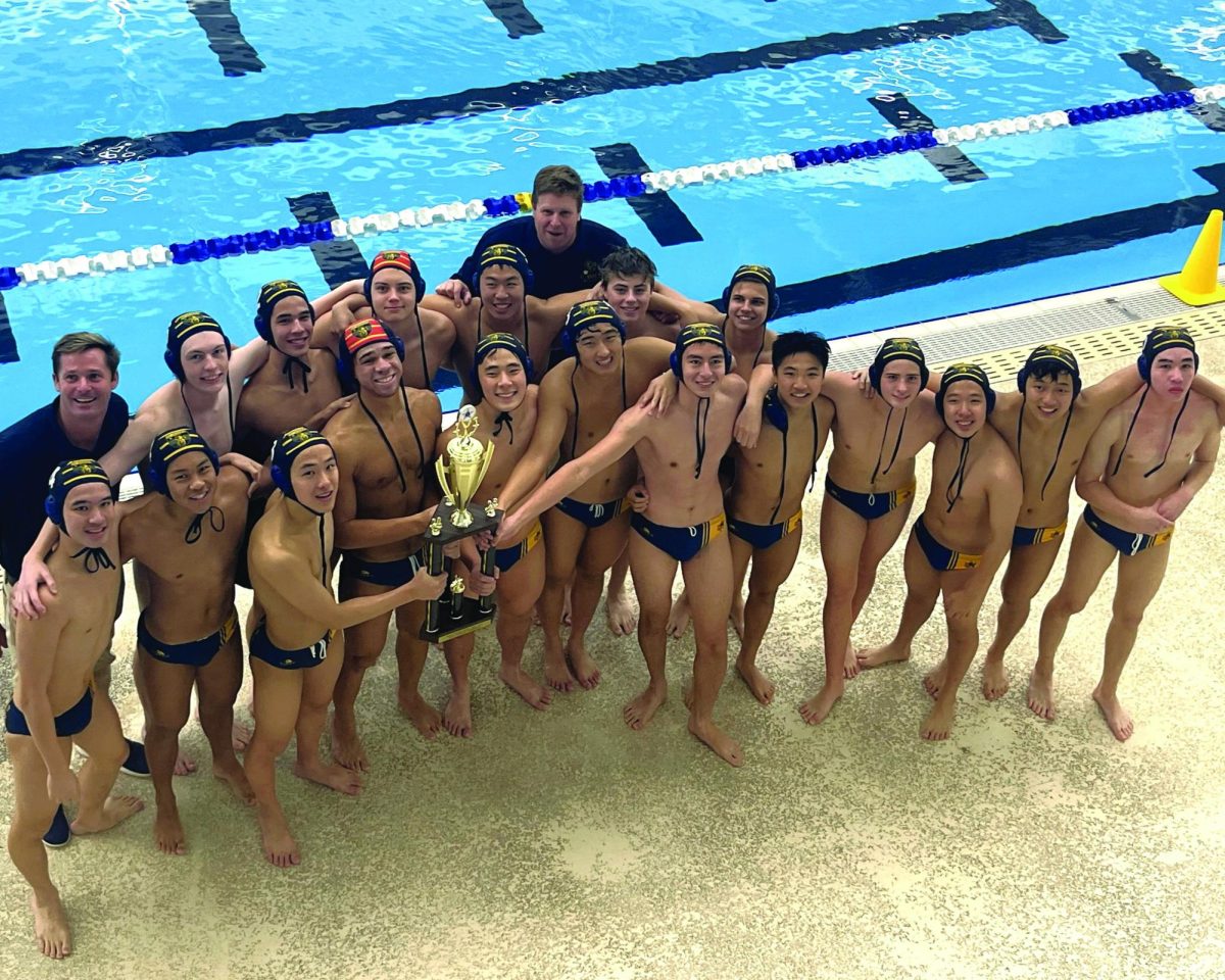 The water polo team lifts the state championship trophy.