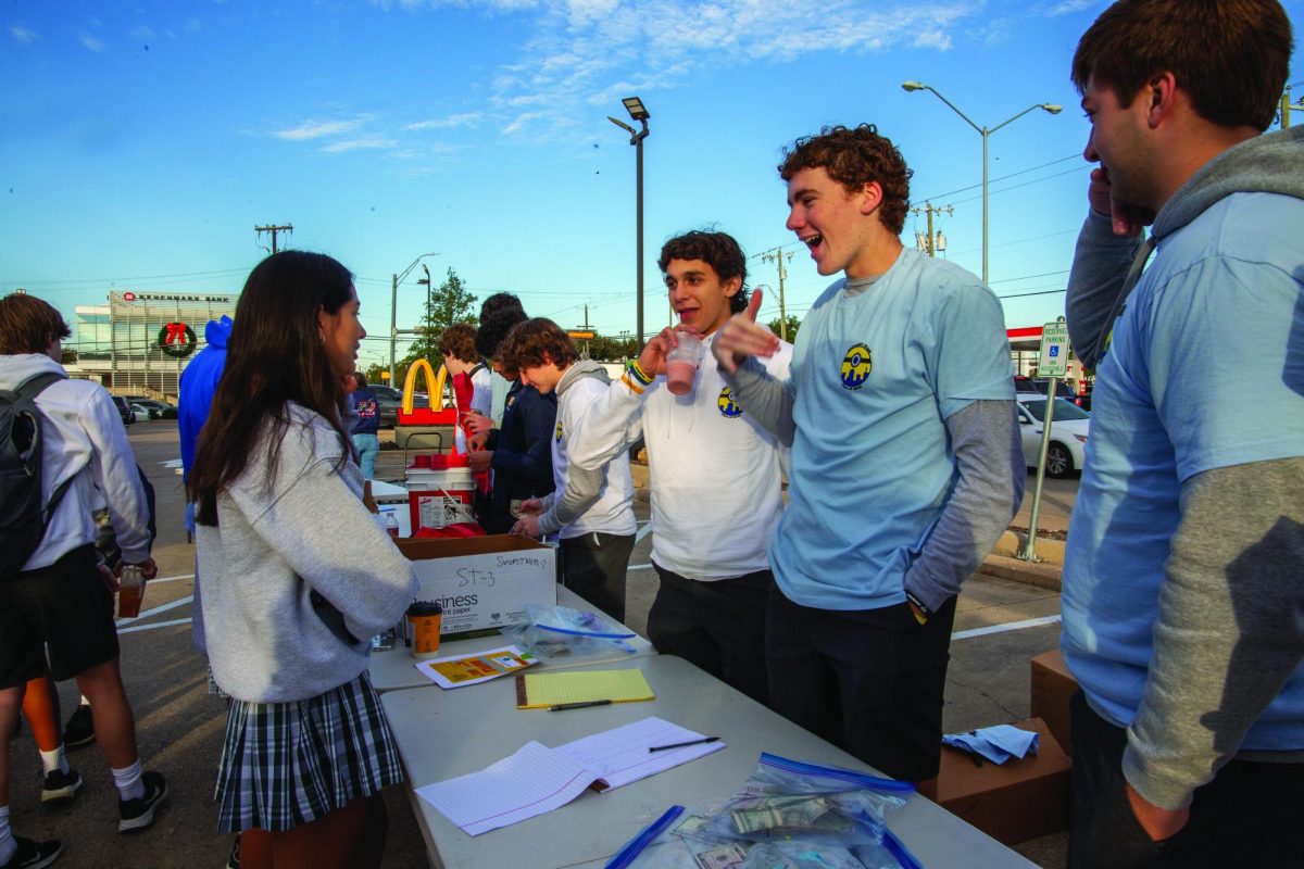 Junior Matthew Hofmann sells t-shirts and wristbands to students during McDonalds Week.
