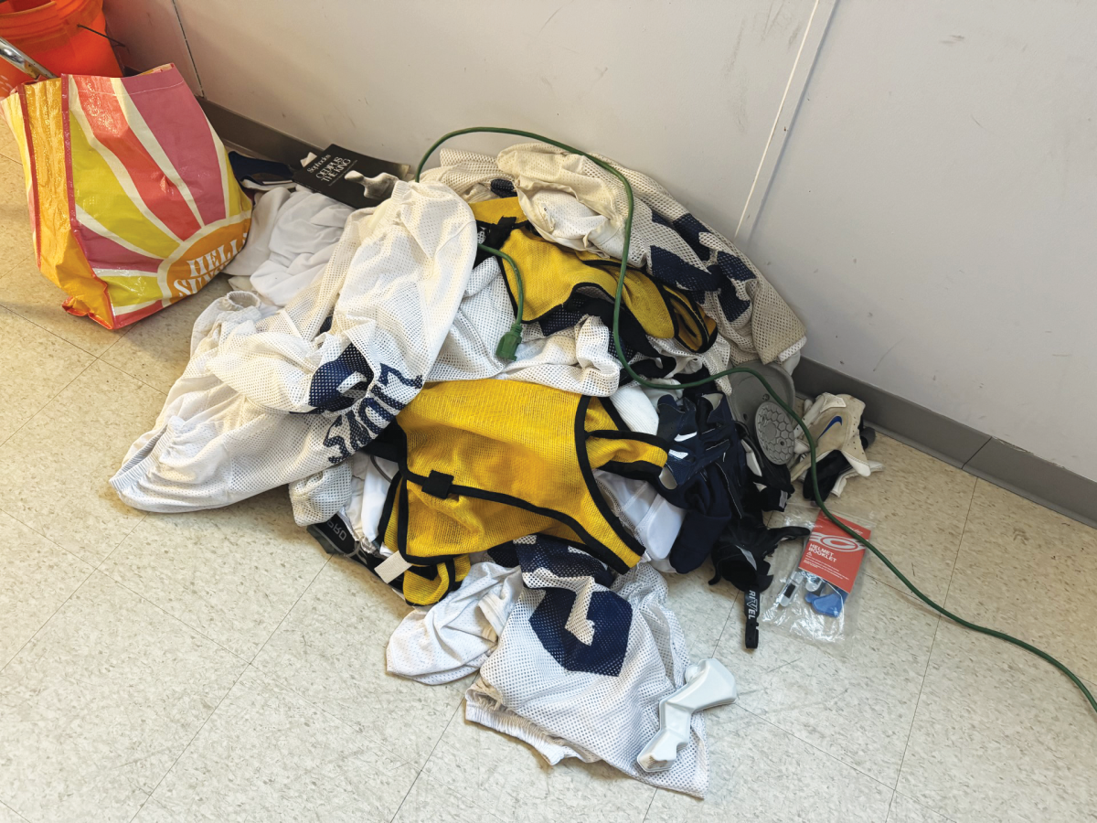 A pile of unclaimed football gear sits in the locker room.