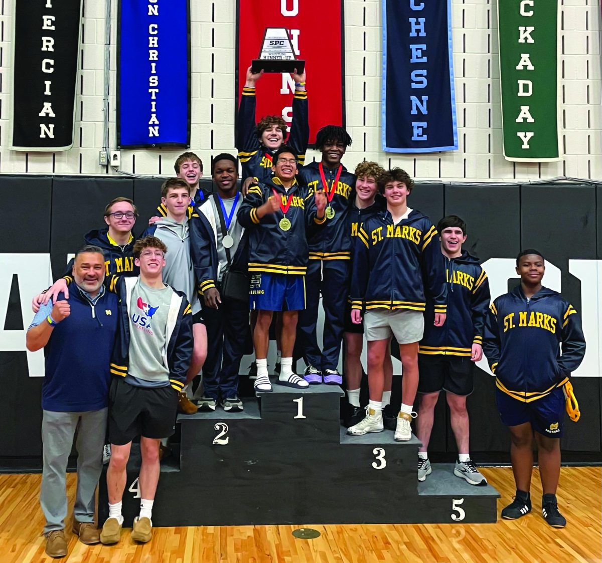 PODIUM+The+Lions+wrestling+team+takes+a+picture+on+the+SPC+podium%2C+with+many+wrestlers+wearing+their+medals+from+a+successful+tournament.