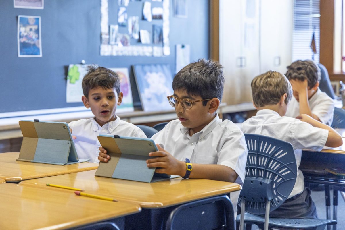 HANDS ON Second graders Declan Tolia and Hridaan Soni use iPads in their Lower School classroom. 