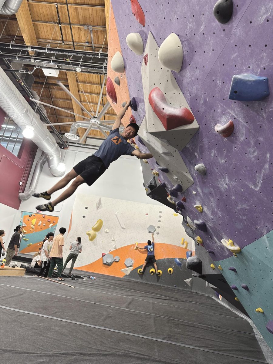MOVING UP Junior Andrew Jin scales a wall at his local climbing gym.