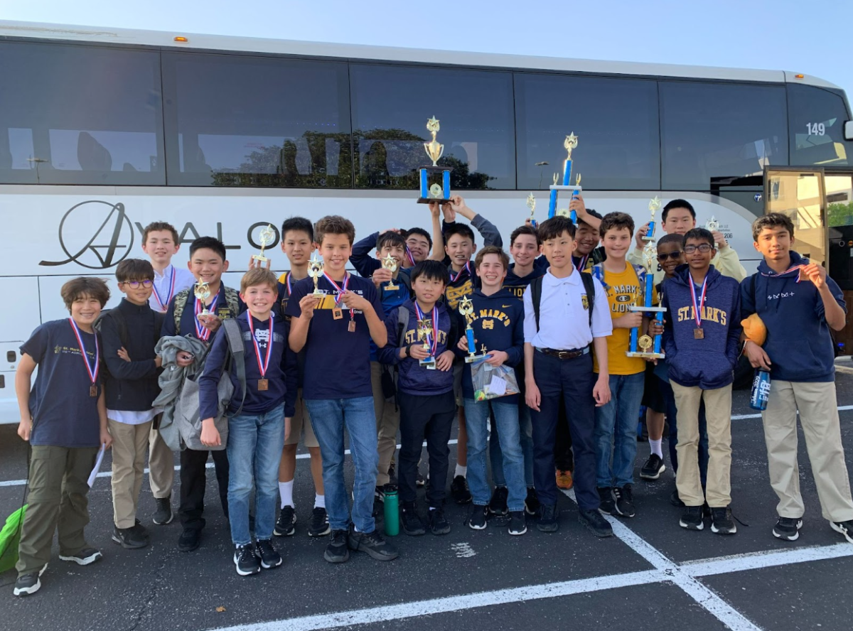 The team poses outside their bus with various awards won during the competition