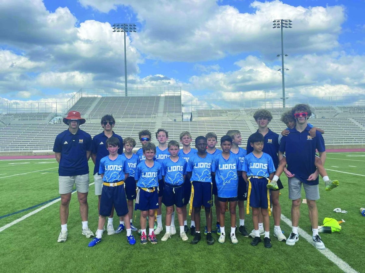 Sophomores coach pose with their Lower School flag football team after a game. 