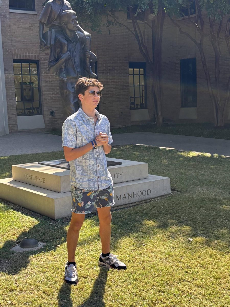 A student stands dressed in the theme for Tropical Tuesday.