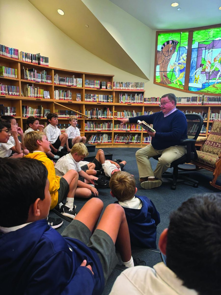 Director of Libraries and Information Services and Director of Upper School Choir Tinsley Silcox reads to a class of third graders.