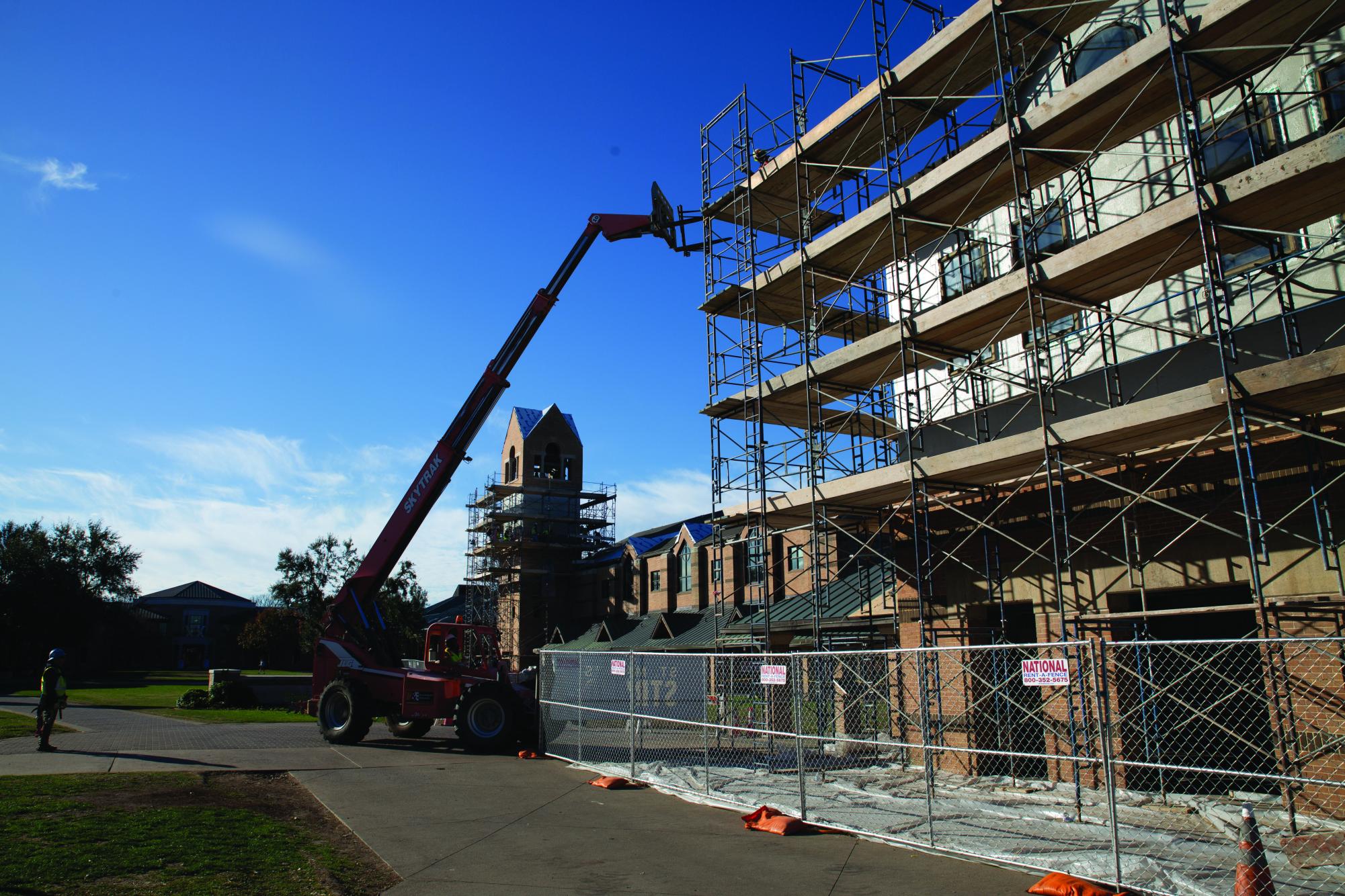 Construction workers repairing the roof of the choir loft.