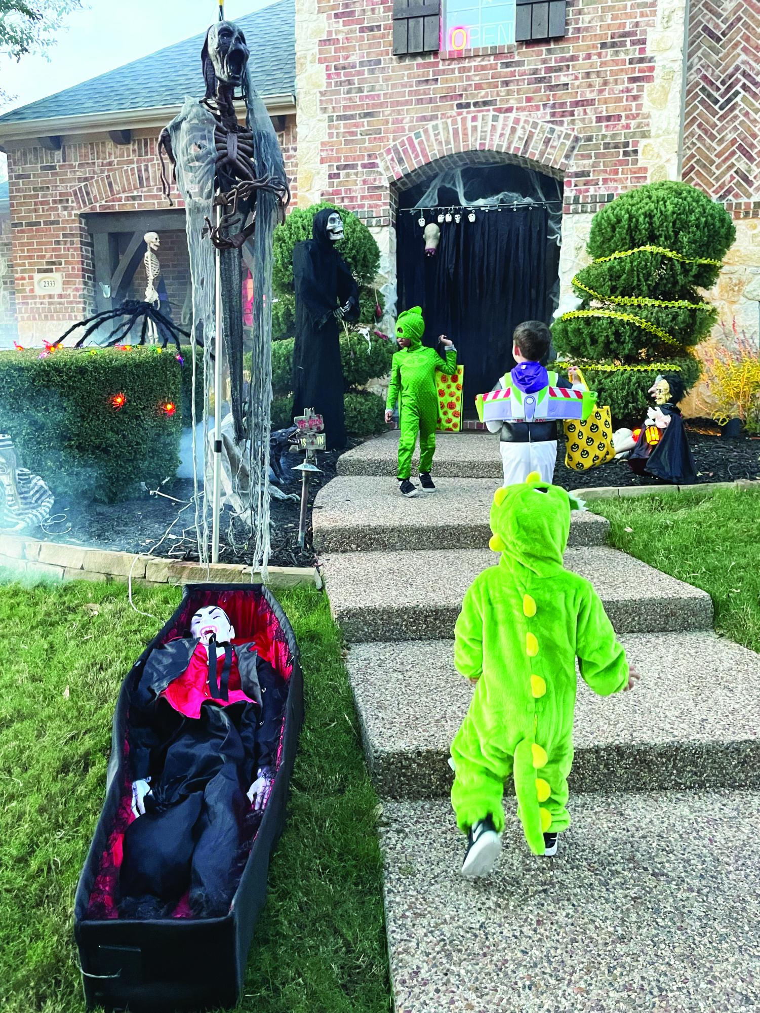 Young children run up to a popular trick-or-treating house.