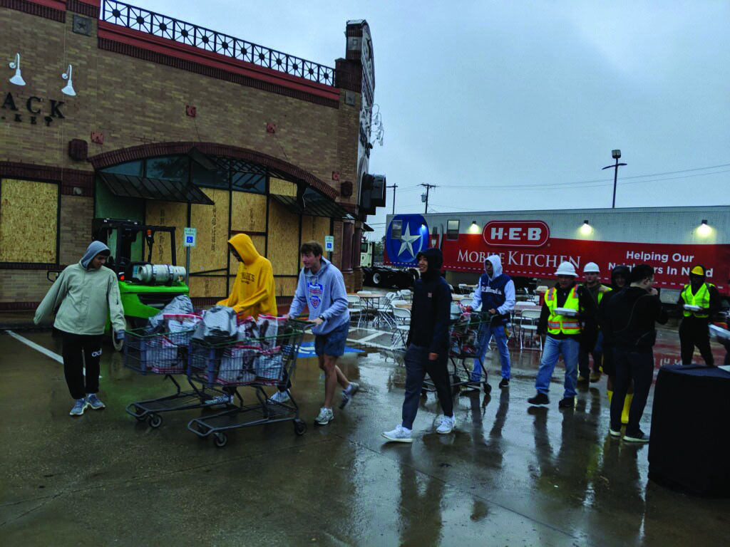 St. Mark’s students (mostly seniors and juniors) work to help move supplies and food in the Preston Royal shopping center for the HEB mobile kitchen.
