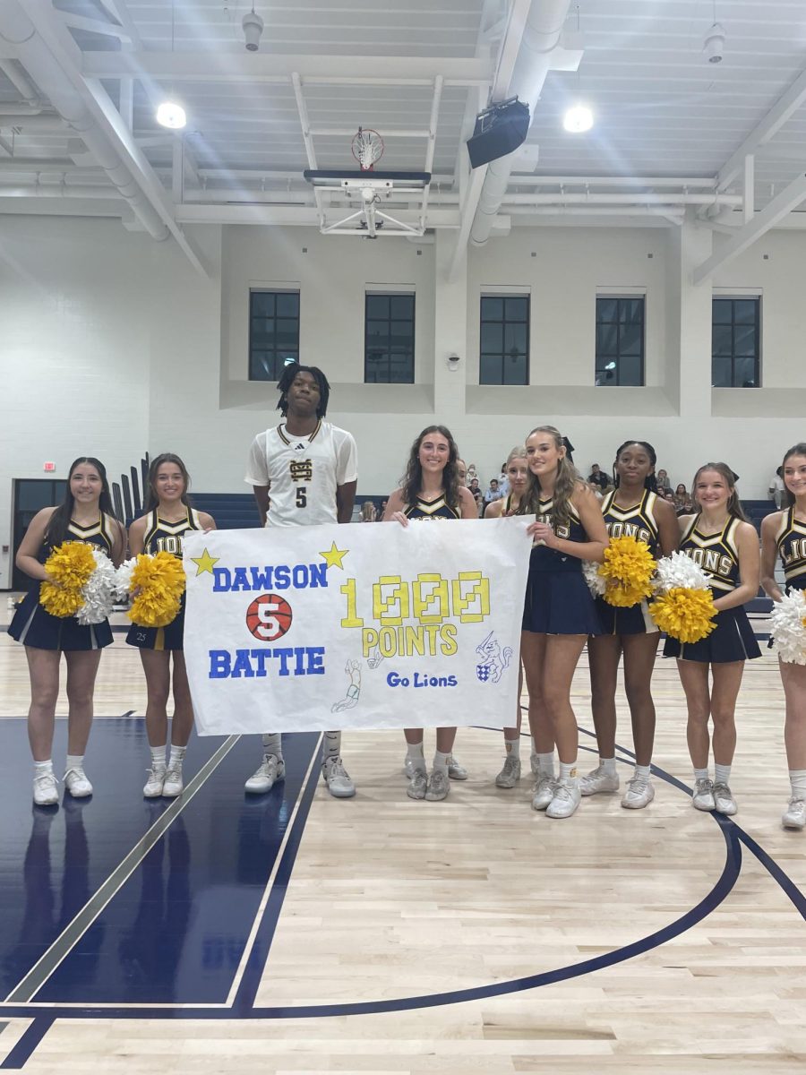 Battie poses with a poster after reaching 1000 points