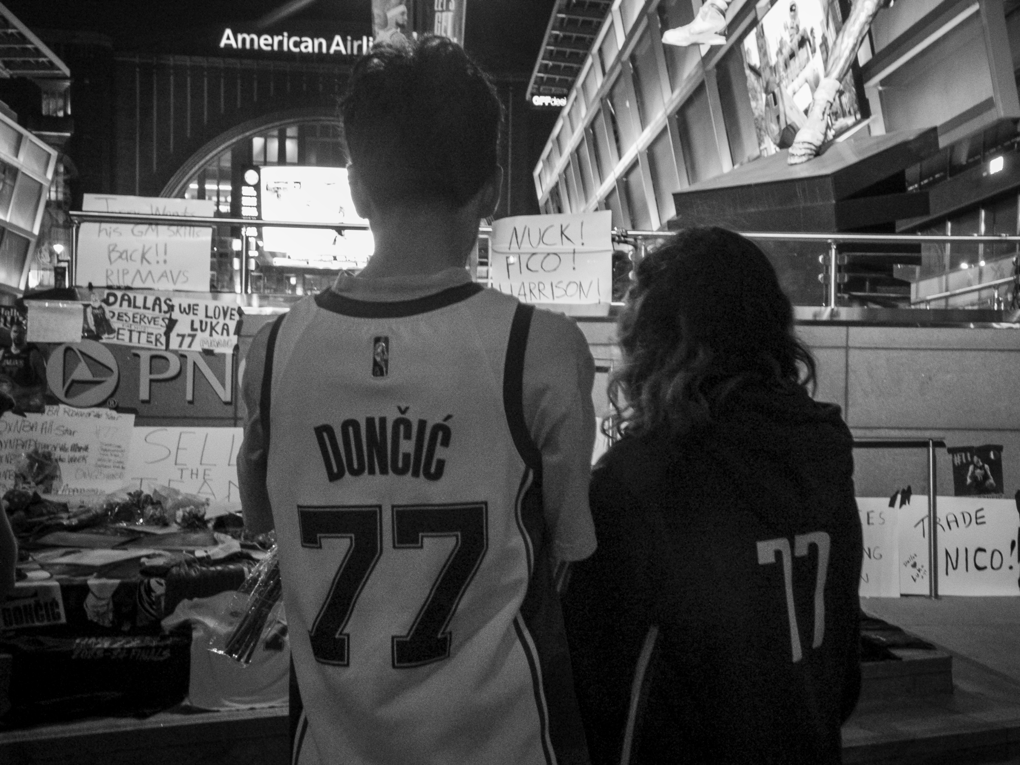 Two fans look over the memorial Mav's fans made for Luka at PNC Plaza outside American Airlines Center where the Mavs play. 