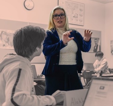 Middle School Humanities Department Head Danielle Maxfield helps a student understand an assignment 