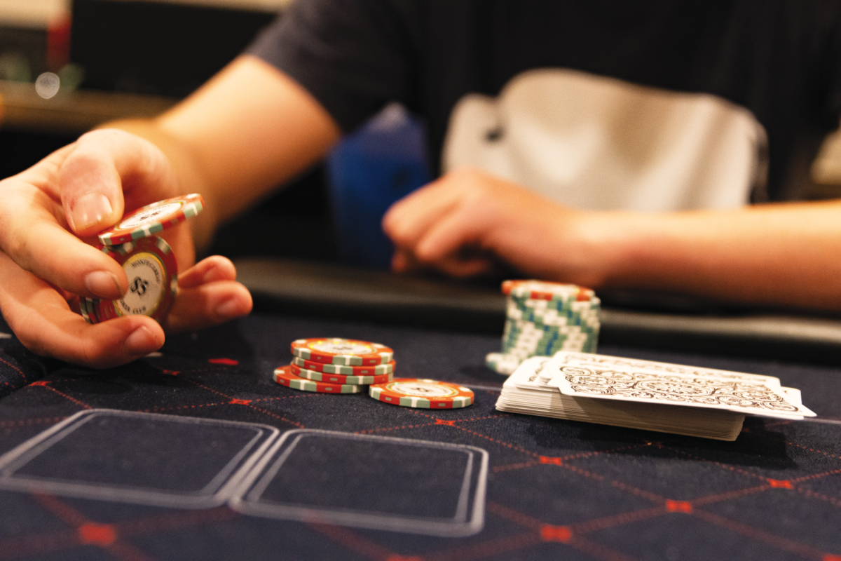 A student
nervously
shuffles his
poker chips, his mind
racing with
strategy.