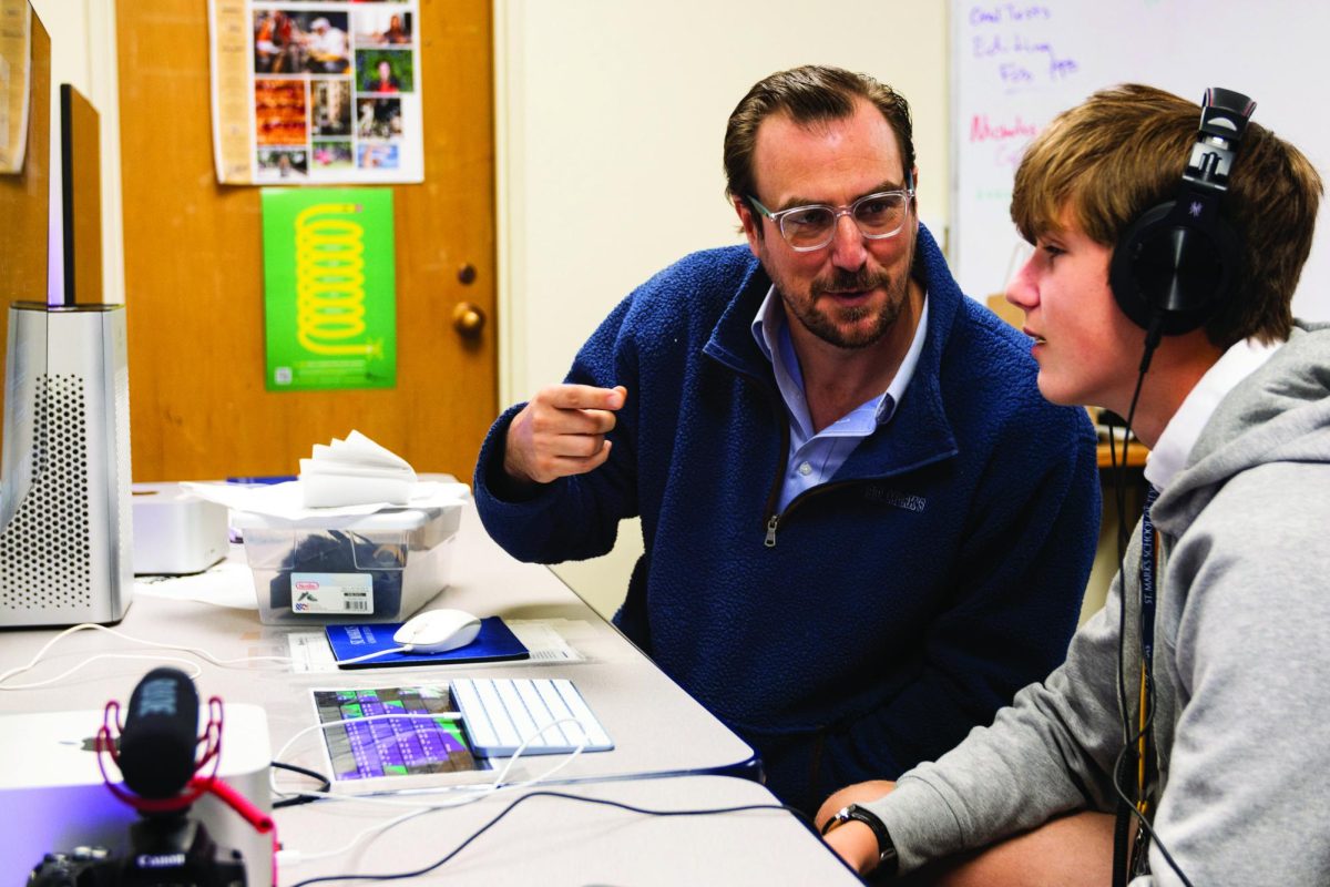 Film Studies Teacher Mark Scheibmeir  helps eighth grader Pierce Tevis edit his film.