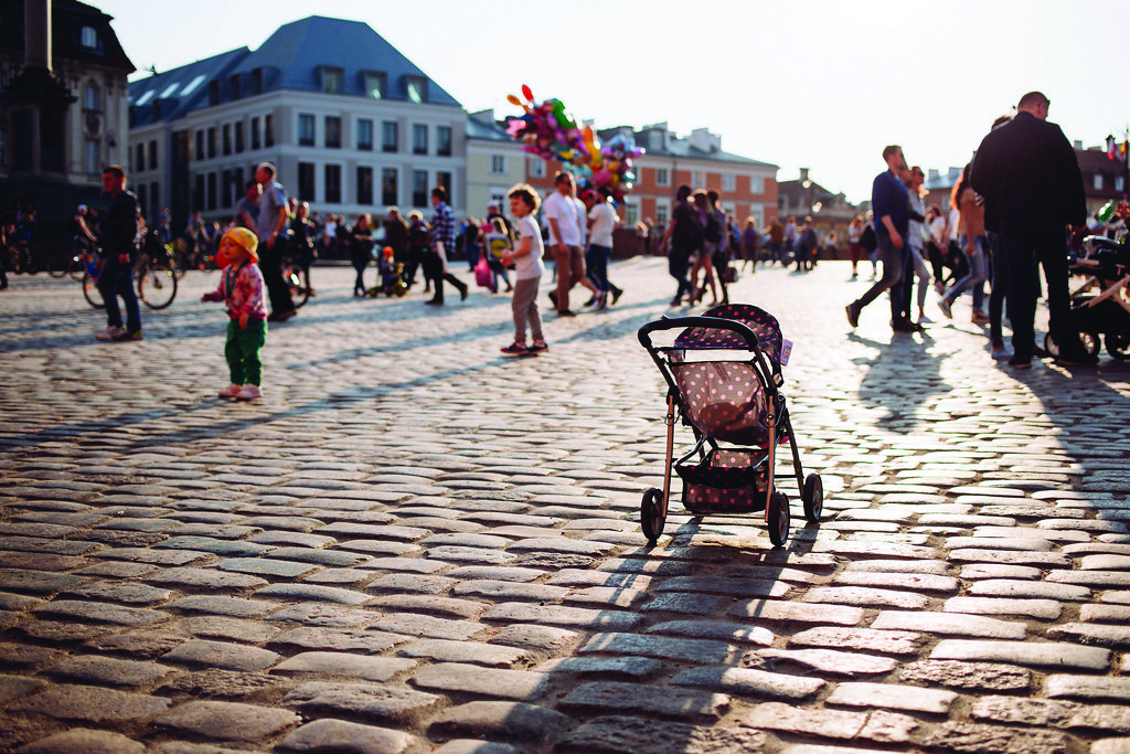 An lone baby stroller rolls on the sidewalk, left completely empty.