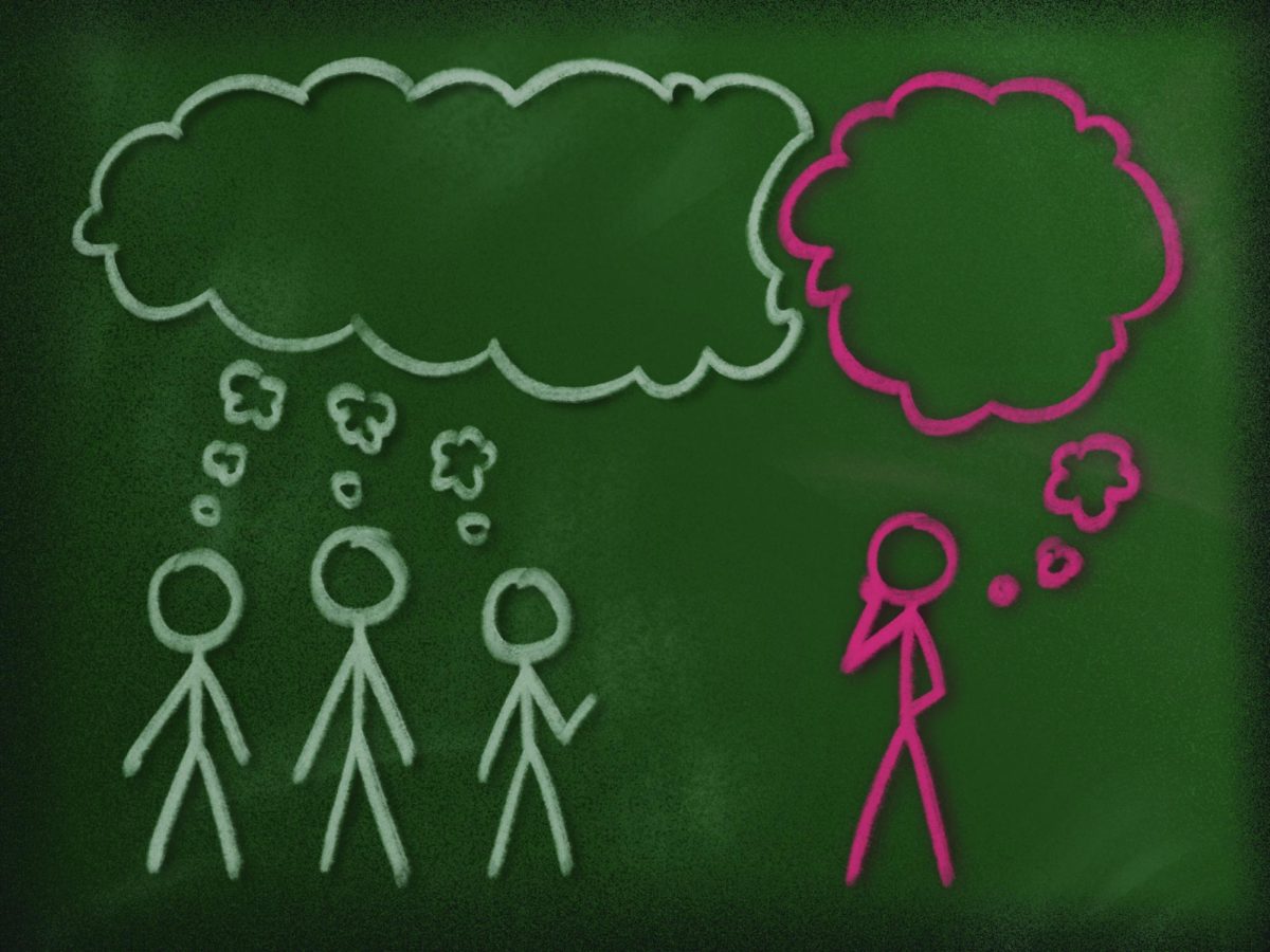 A student stands apart from the group, considering whether to voice an unpopular opinion.
