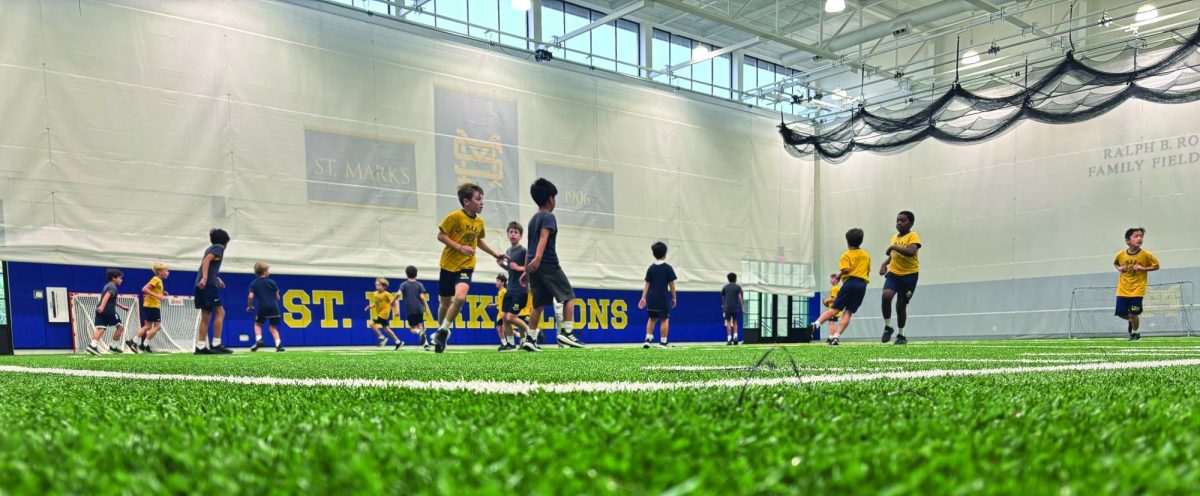 A class of 2nd grade students play indoor football in the fieldhouse for P.E. on a cold day. 