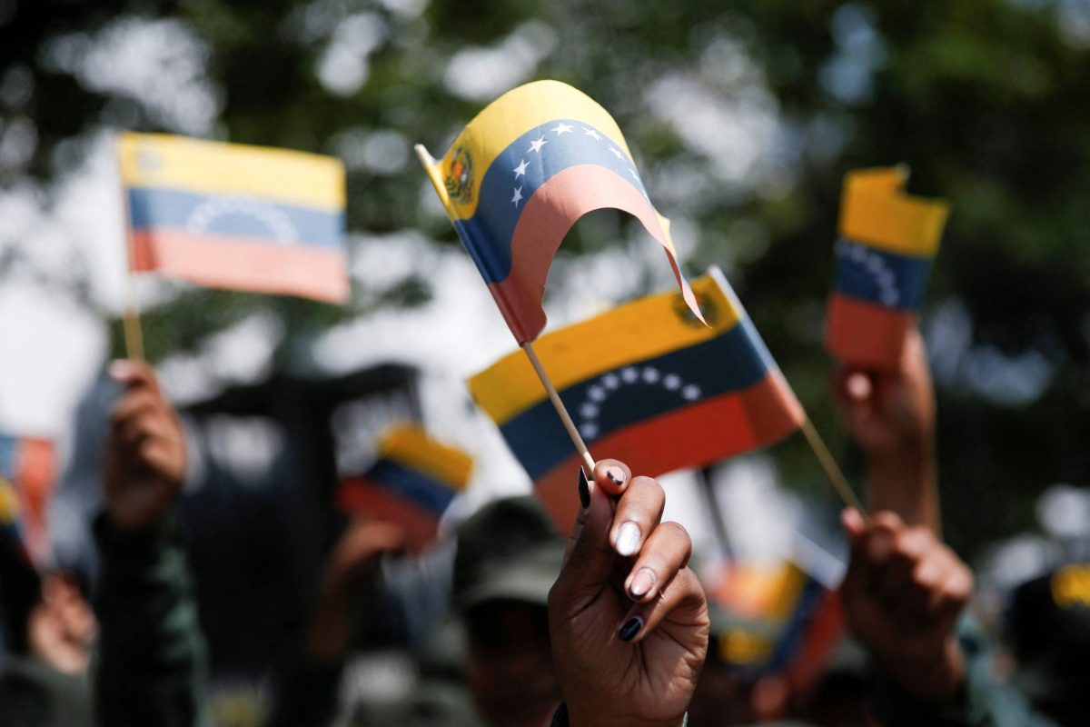 Government supporters hold Venezuelan flags during a women's march toward the office of interim President Delcy Rodriguez, days after the U.S. launched a strike on Venezuela and captured President Nicolas Maduro and his wife Cilia Flores, in Caracas, Venezuela, January 6, 2026. 