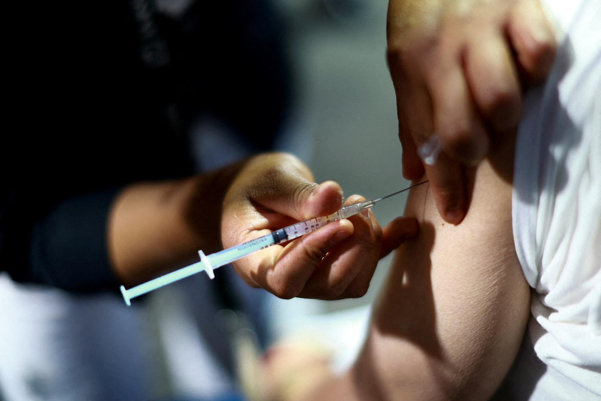 A nurse administers a dose of the measles vaccine to a man during a vaccination campaign in response to a measles outbreak.