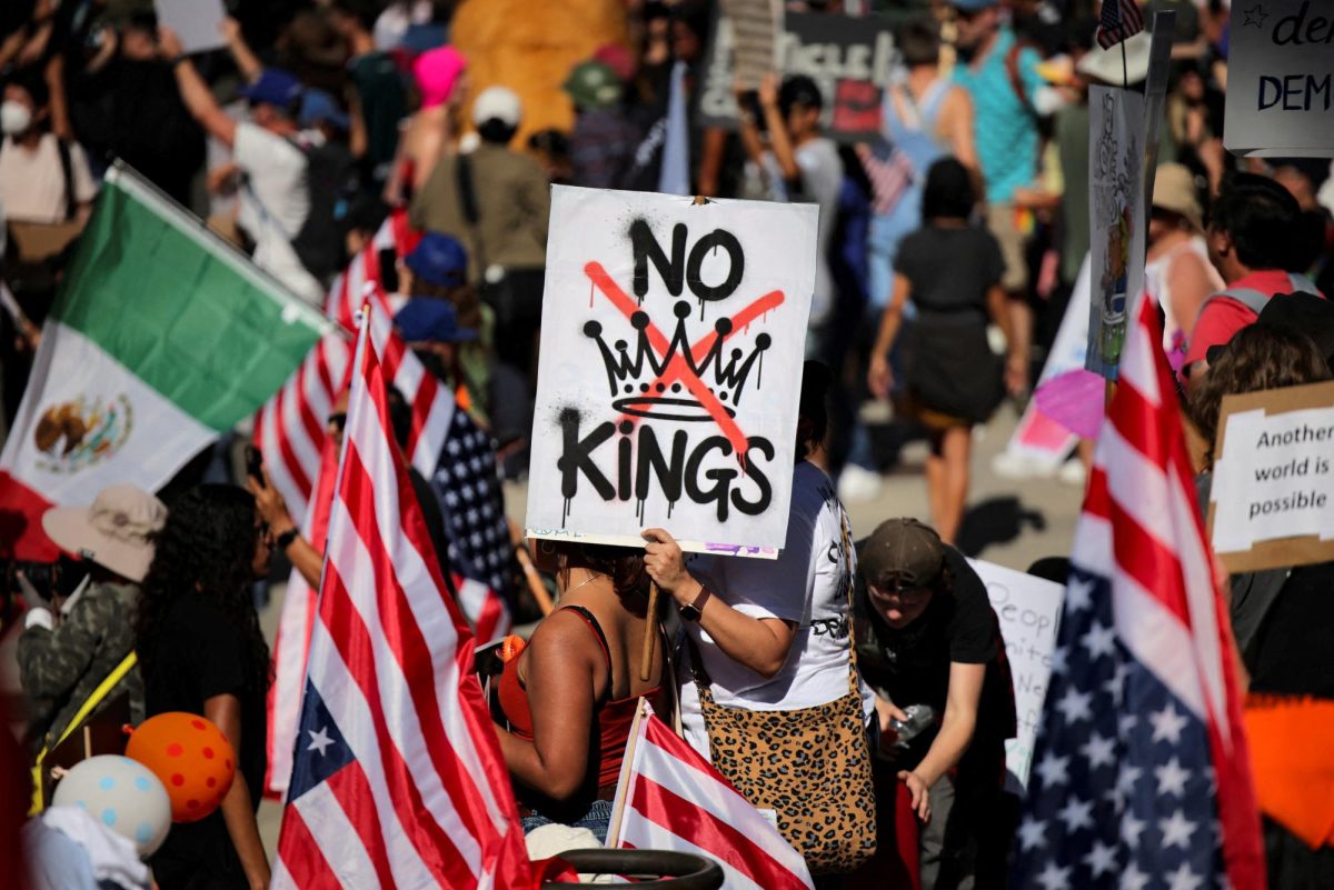 A protester holds a sign reading "NO KINGS" with a crown illustration crossed out during a "No Kings" protest against U.S. President Donald Trump's policies, outside City Hall in Los Angeles, California, U.S., October 18, 2025. 