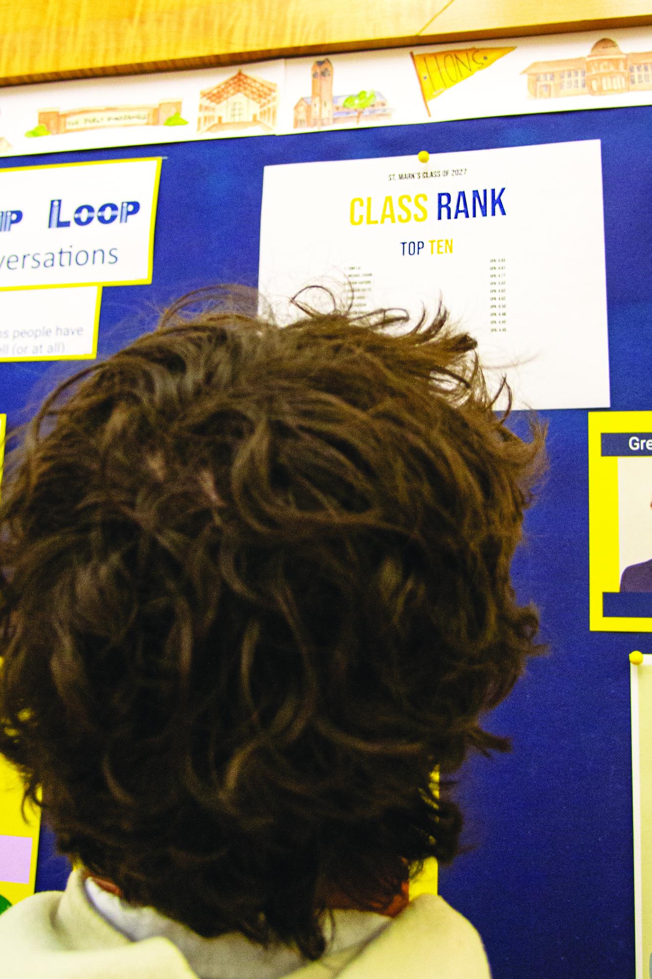 A student studies academic rankings, measuring his success against others.