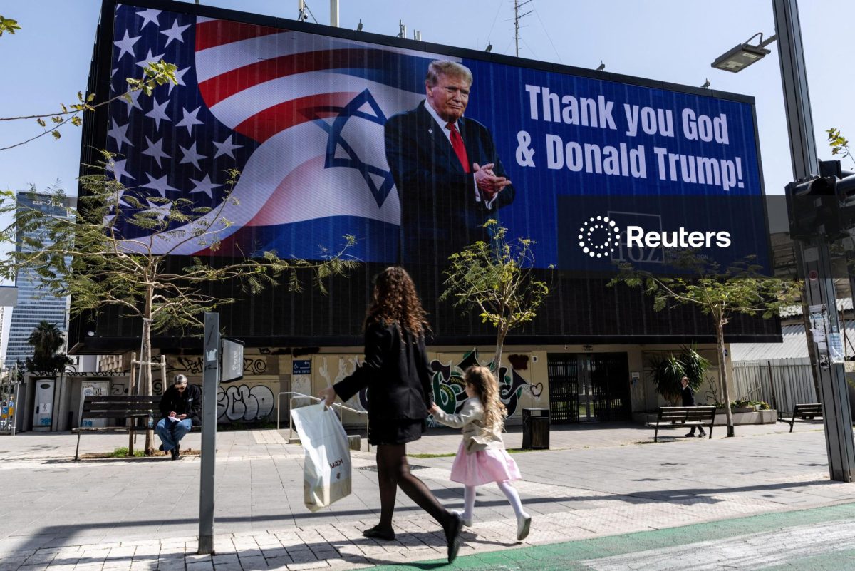People walk by a billboard commissioned by an evangelical group, which displays a picture of U.S. President Donald Trump with the words "Thank you God & Donald Trump", amid the U.S.-Israel conflict with Iran, in Tel Aviv, Israel, March 12, 2026. REUTERS/Nir Elias