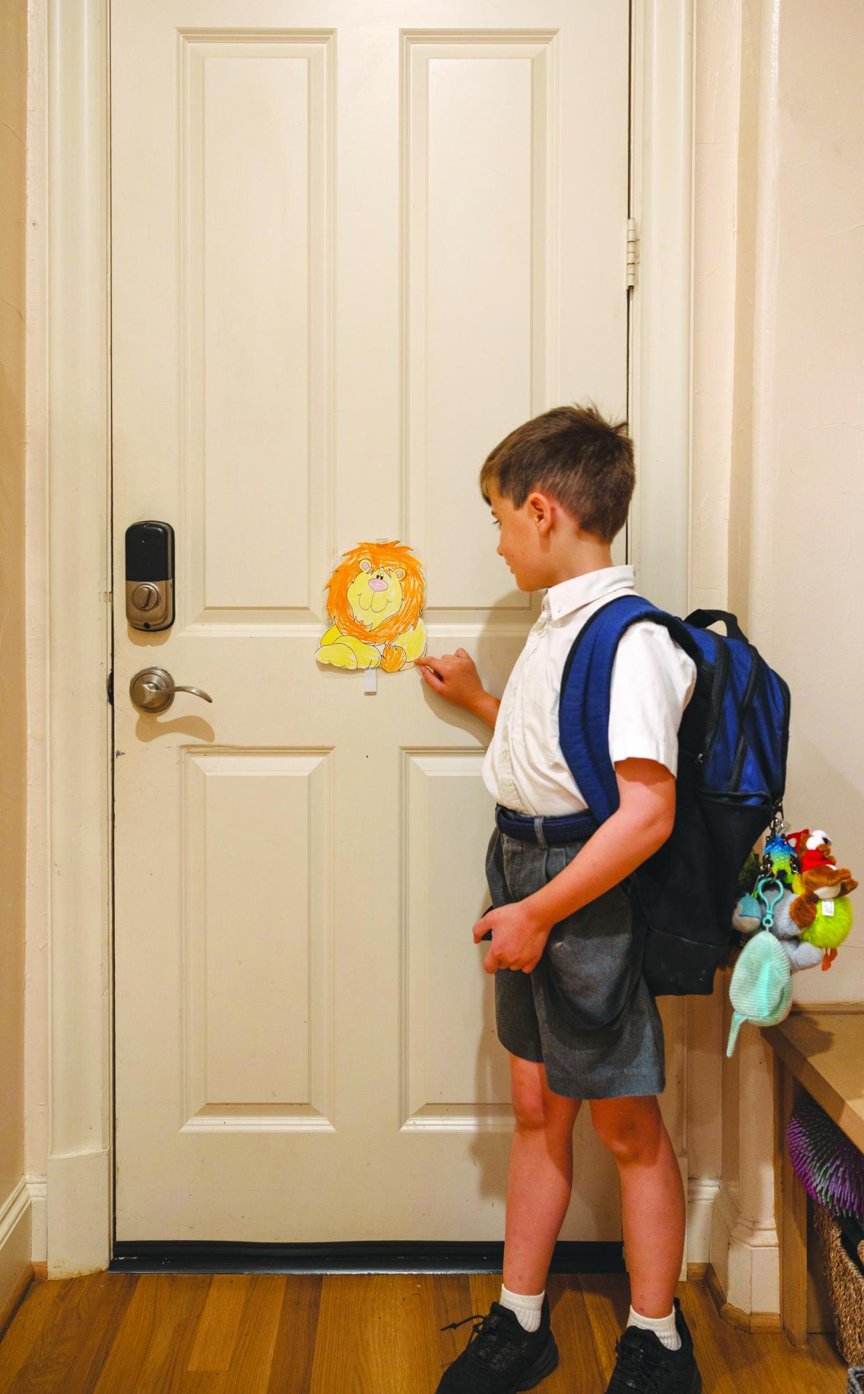 Before leaving for school, second grader Charles Radman touches his “Checkpoint Charlie” lion.